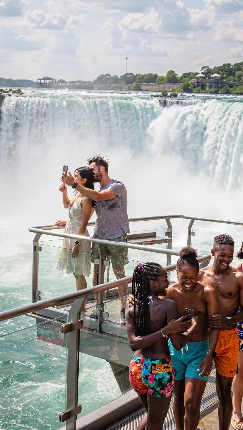Группа туристов на платной панорамной площадке с панорамными окнами и панорамным видом на каньон.